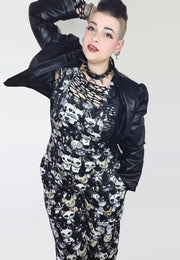Model wearing black and white dungarees with a print of cute but gothic punk alley cats. Alternative cats print overalls. 