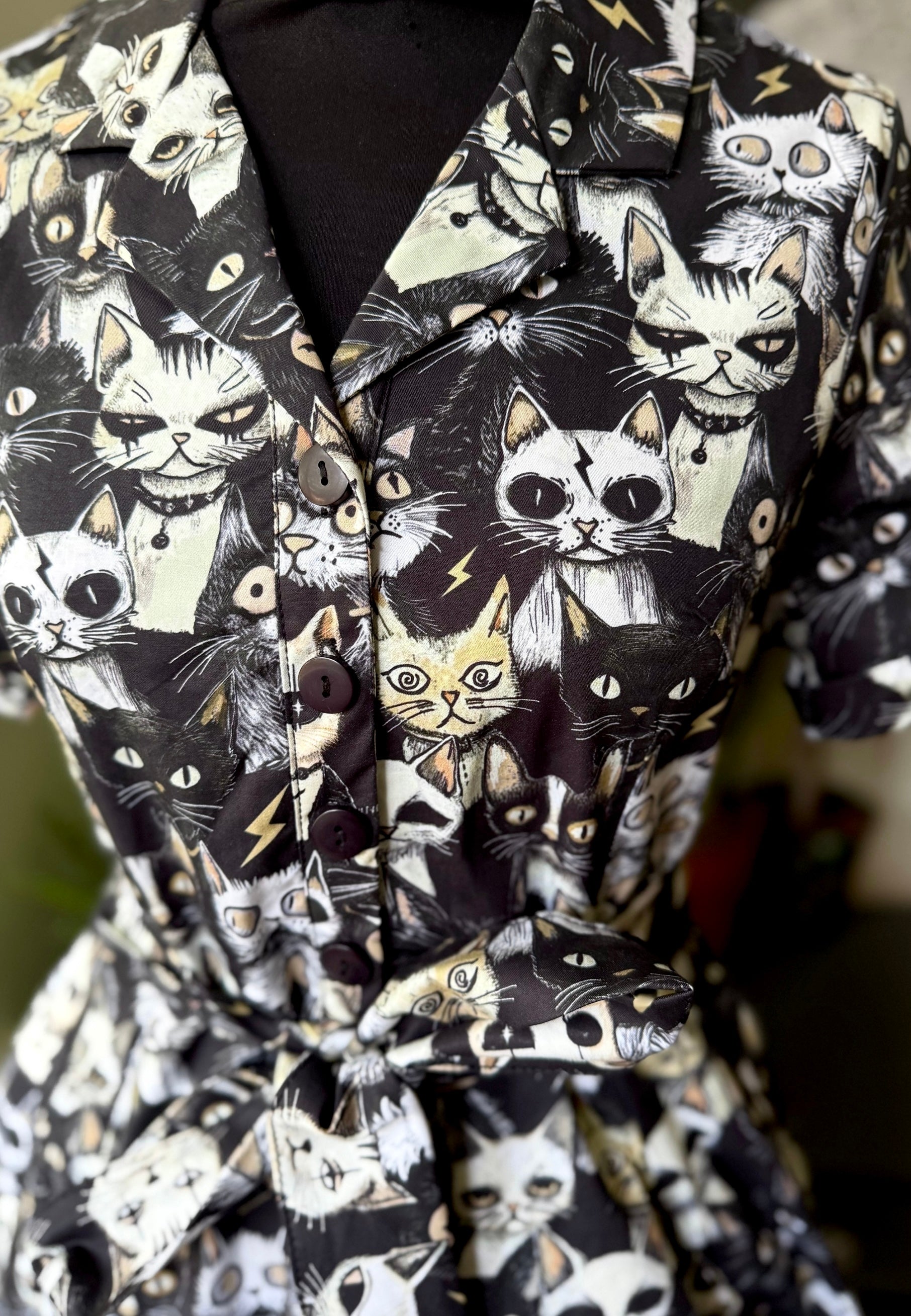 Close up photo of a shirt dress with a quirky Alley cats print