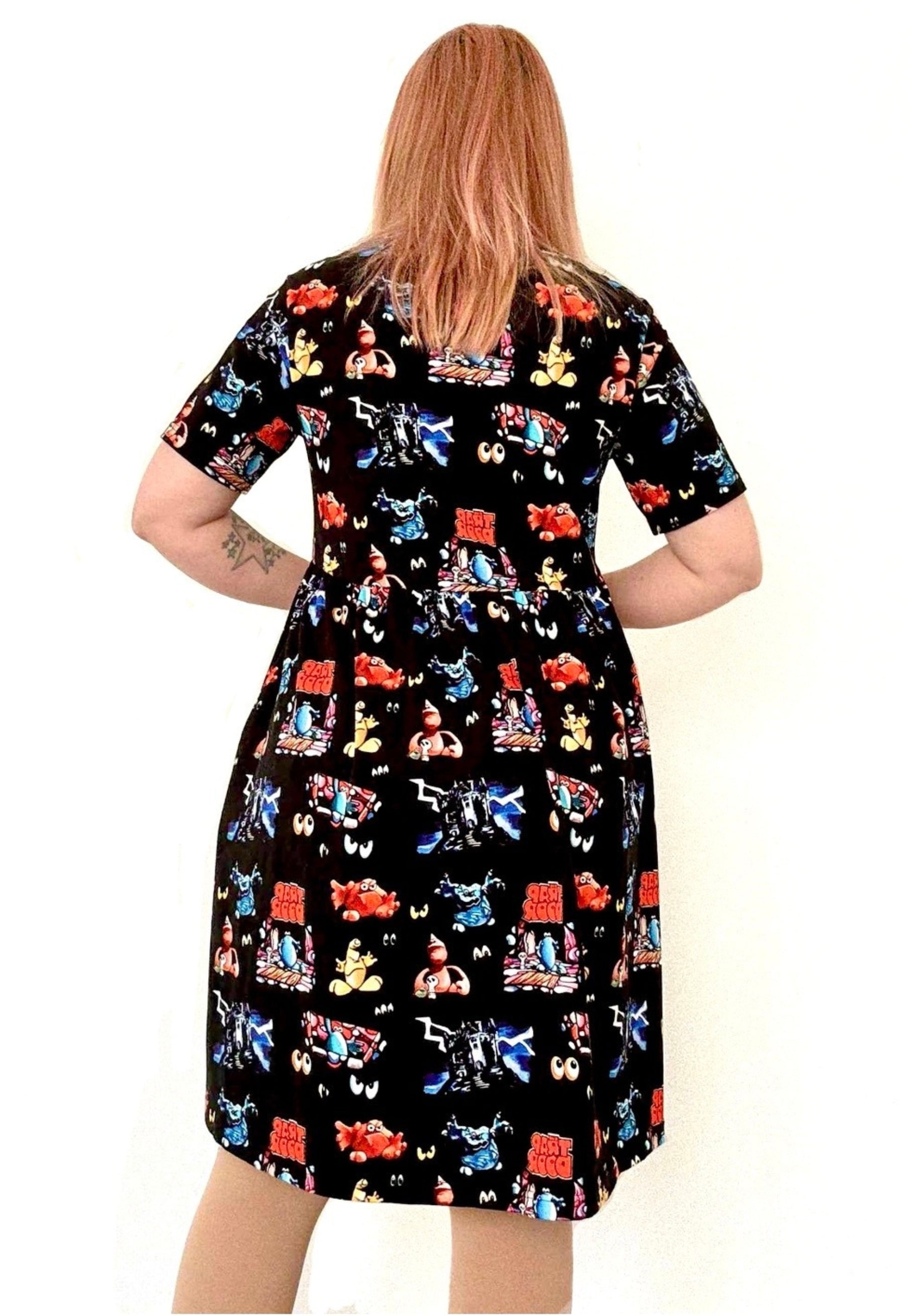 Back view of a woman wearing a black dress with a vibrant design of the 1980s children’s tv programme Trap Door