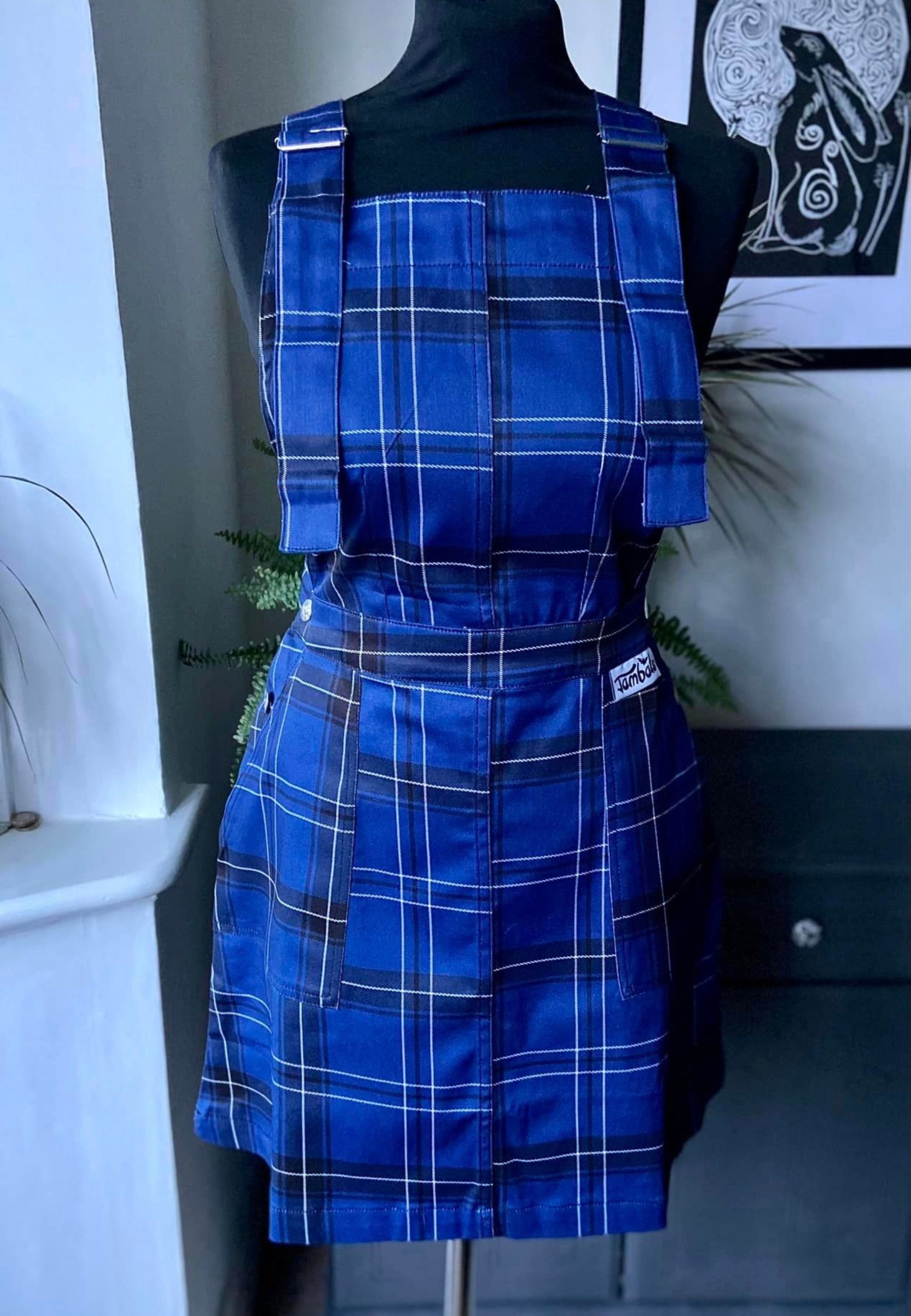 Classic blue tartan pinafore dress in a soft but sturdy stretch cotton twill. Deep hip pockets and side button fastenings with our unique Jambats batty buttons. Soft stretch cotton twill.