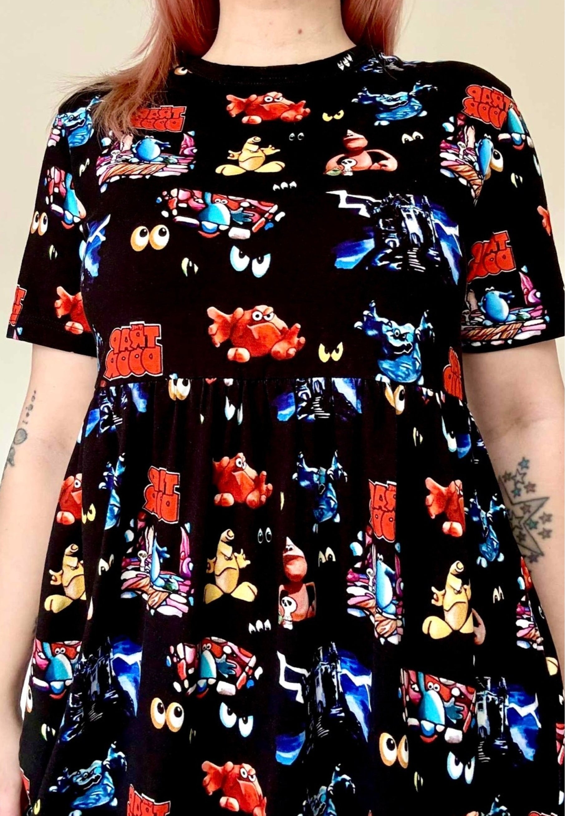 Black dress with colourful Trap Door print worn. Close up of the dress fabric.