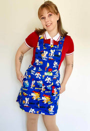 Woman wearing a blue Jambats pinafore dress with the retro 80s cartoon characters DangerMouse on the print. Officially licensed