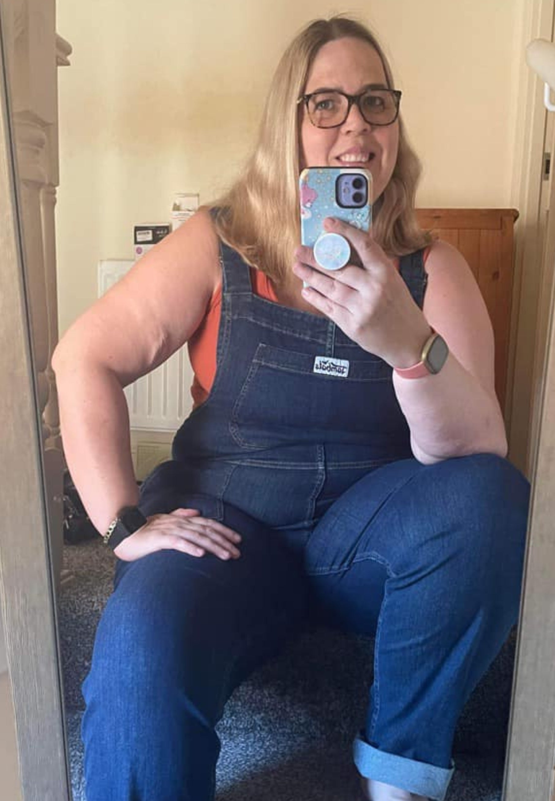 Woman wearing dark denim dungarees. 