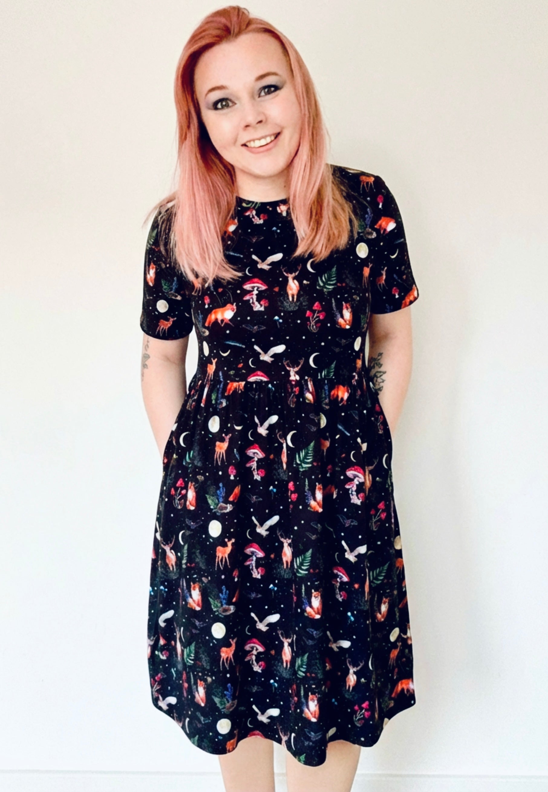 Woman in black smock dress with dark forest pattern 