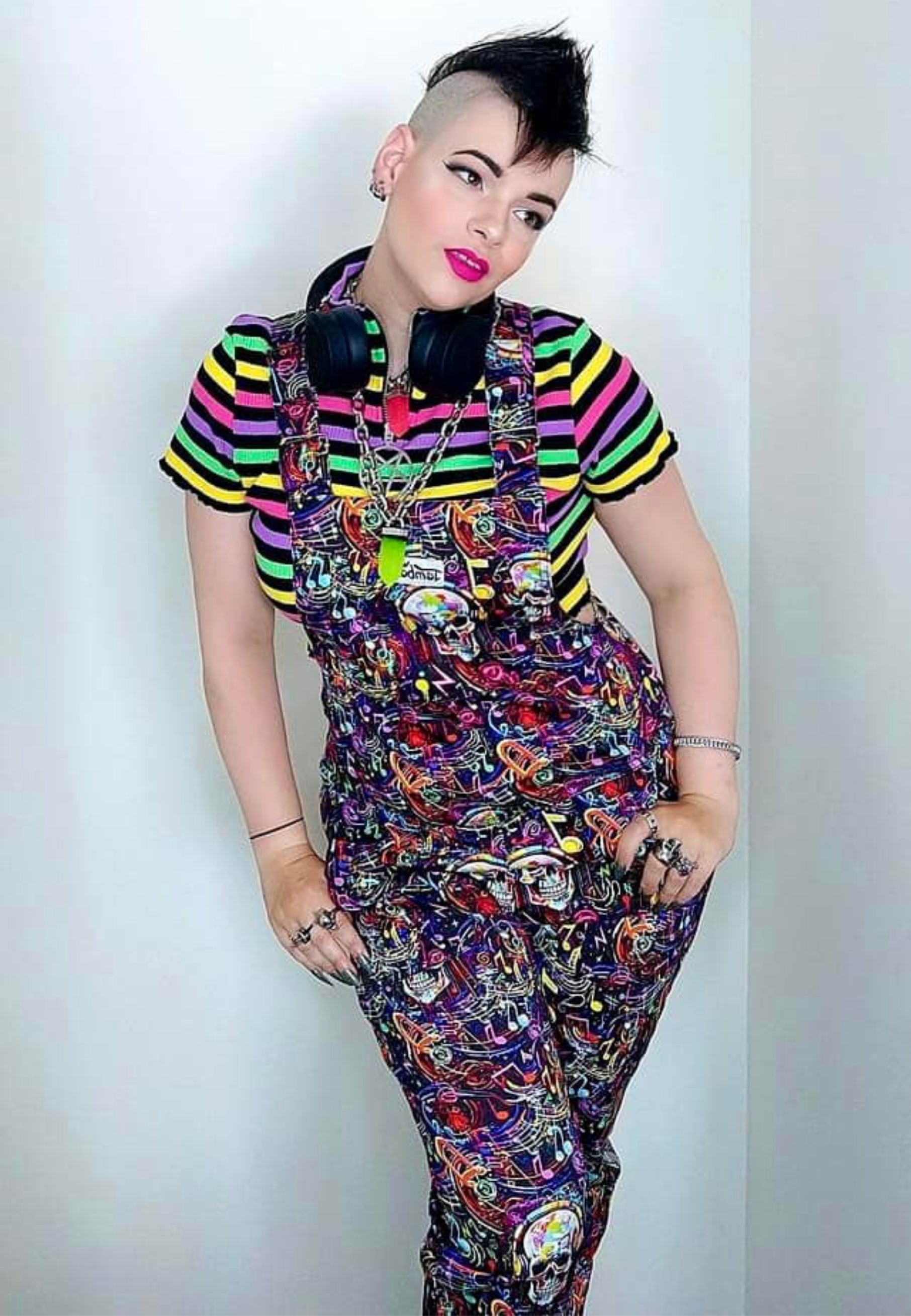 Woman wearing Graffiti Music Skulls Dungarees and music headphones. 80s 90s vibe. 
