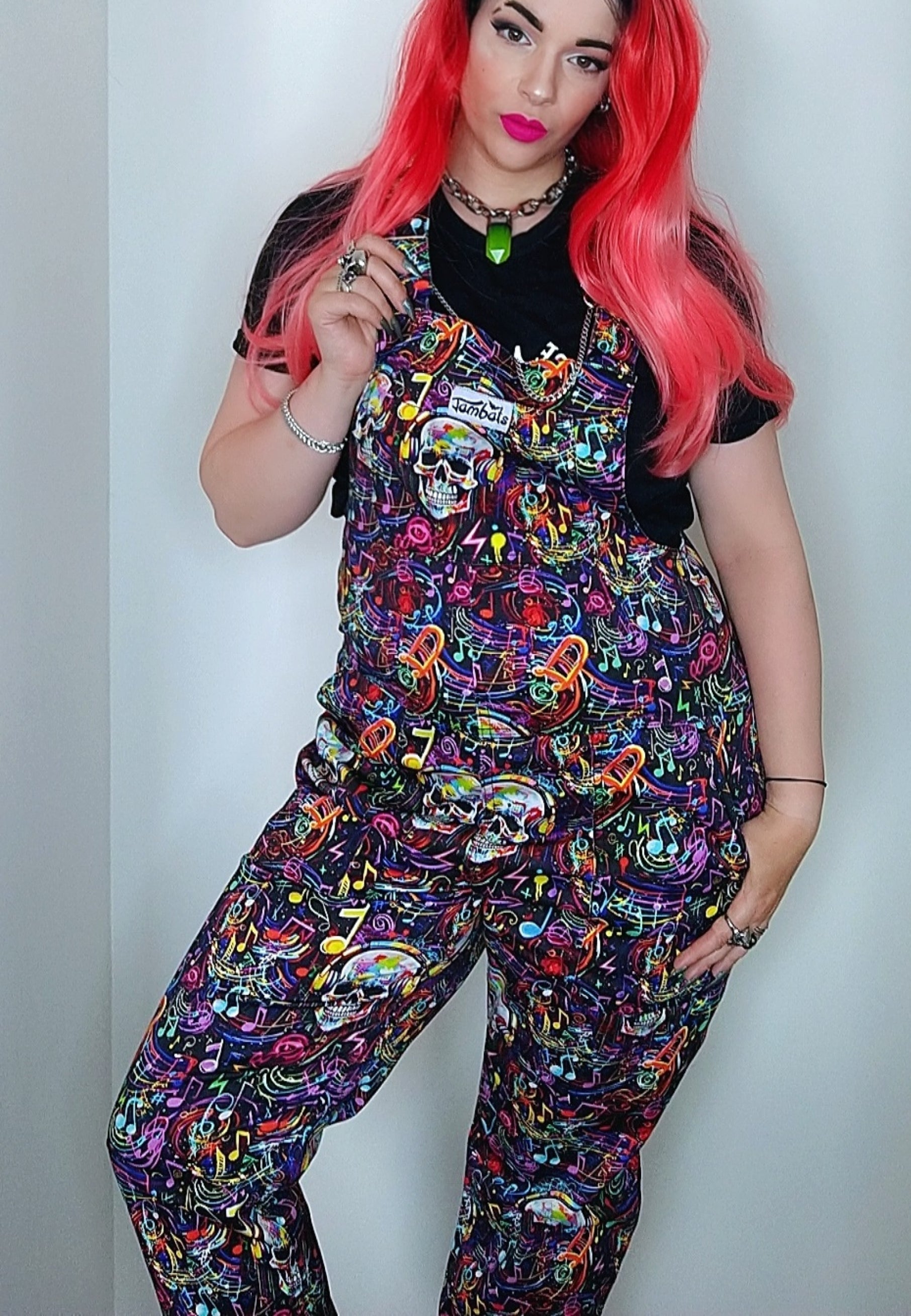 Woman wearing Graffiti Music Skulls Dungarees with long bright red hair. 80s 90s vibe. 
