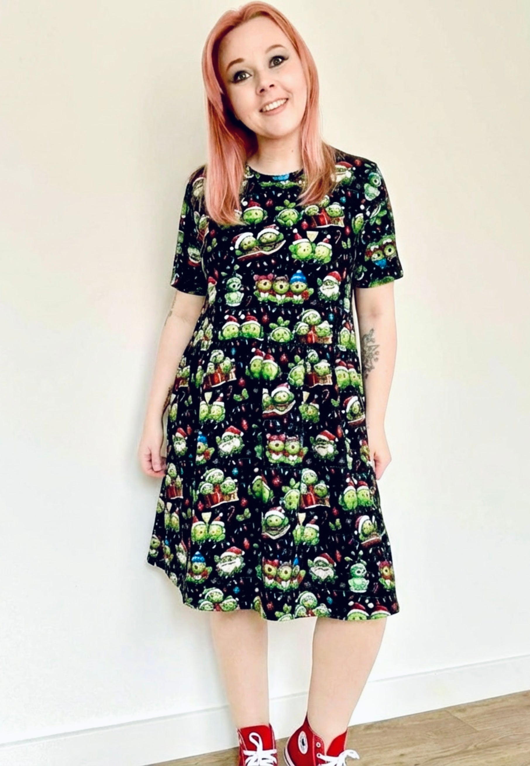 Woman wearing a black Christmas Sprouts smock dress