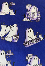 A close-up of a blue fabric with a repeating cute pattern of white ghosts and ghost cats in various playful poses.