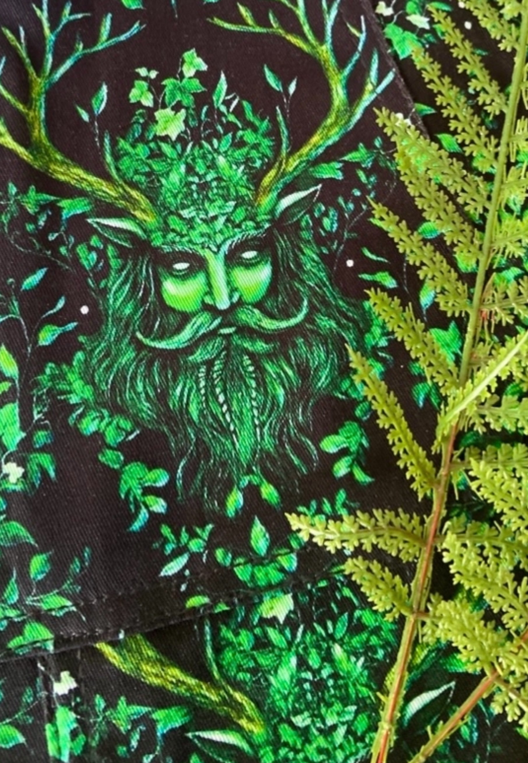 Close up of the Green Man fabric showing a mystical Green Man, entwined in vibes and leaves. 