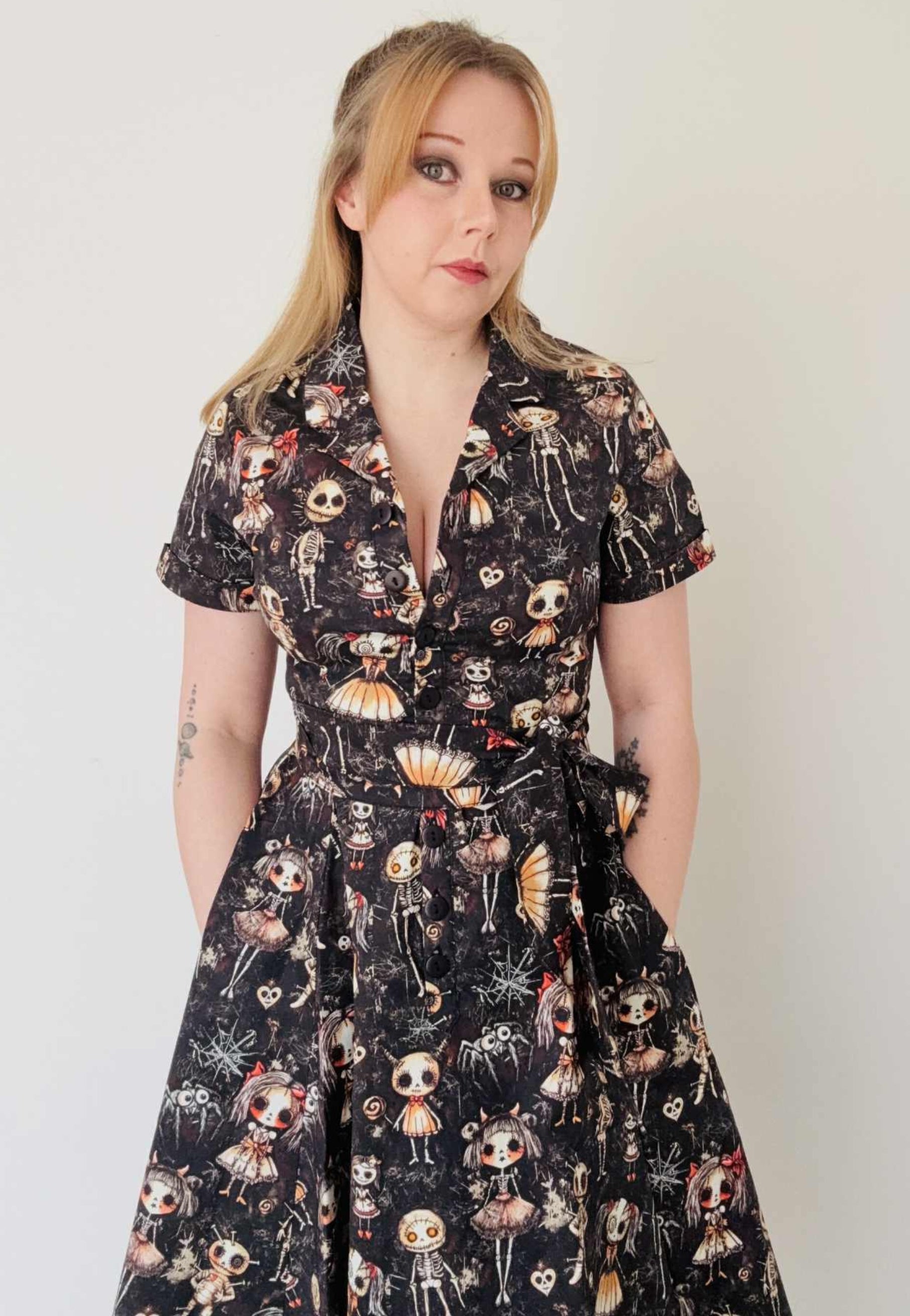 Woman wearing a shirt dress with a fabulous Haunted dolls print. Studio photo. 