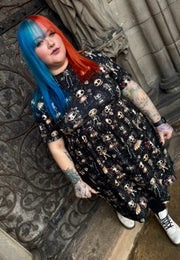 Woman with blue and red hair wearing a black dress with haunted dolls print