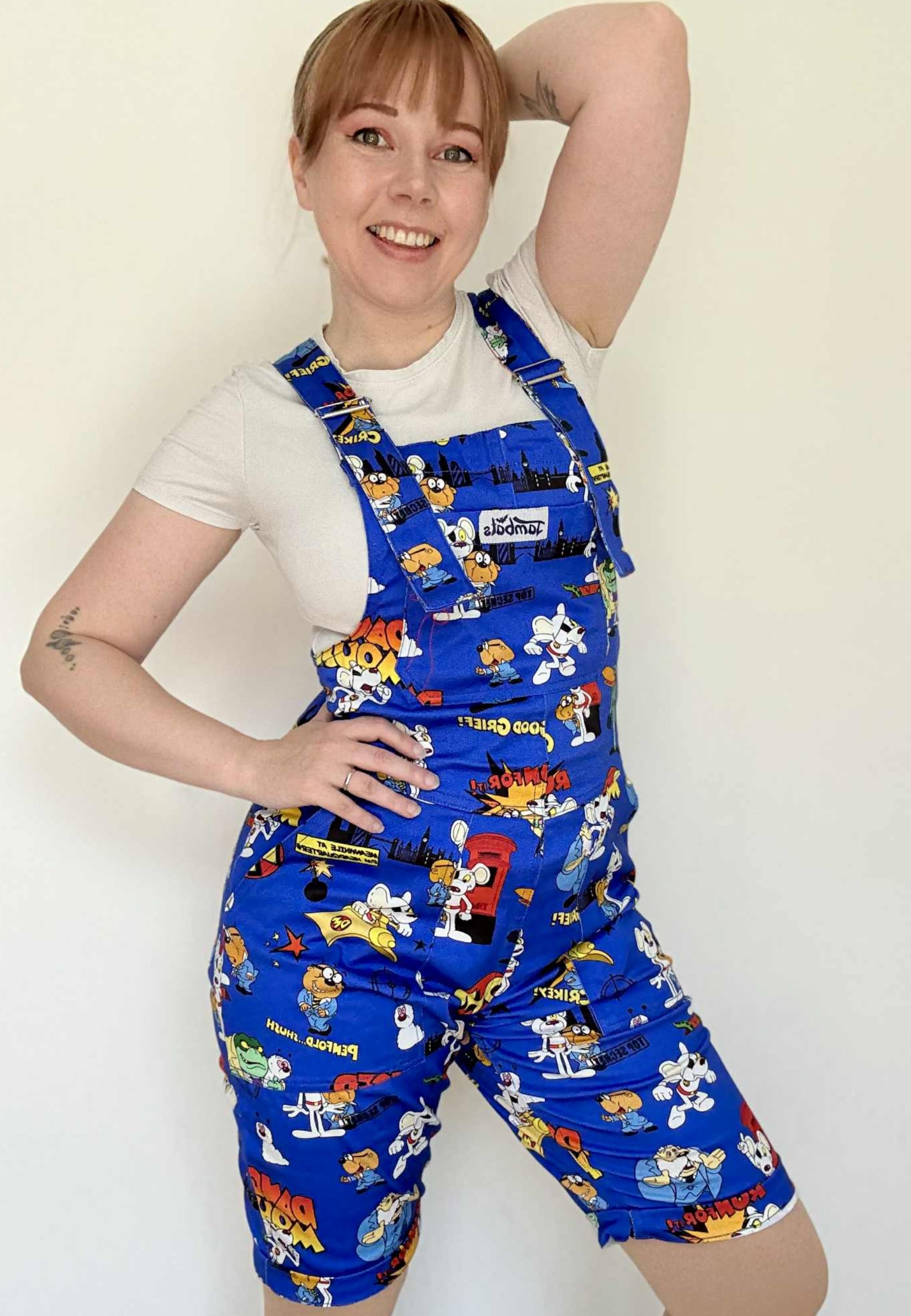 Woman wearing blue Jambats dungarees with the retro 80s cartoon characters DangerMouse on the print. Officially licensed. 1980’s children’s tv character Danger Mouse. 