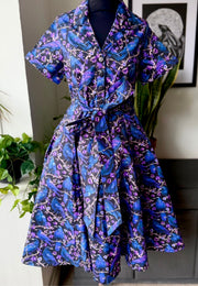 Shirt dress on a mannequin against a neutral background. Pattern on the dress is a beautiful print of ravens and crows.