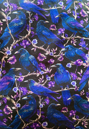 Pattern of blue cries and ravens and purple flowers on a black background
