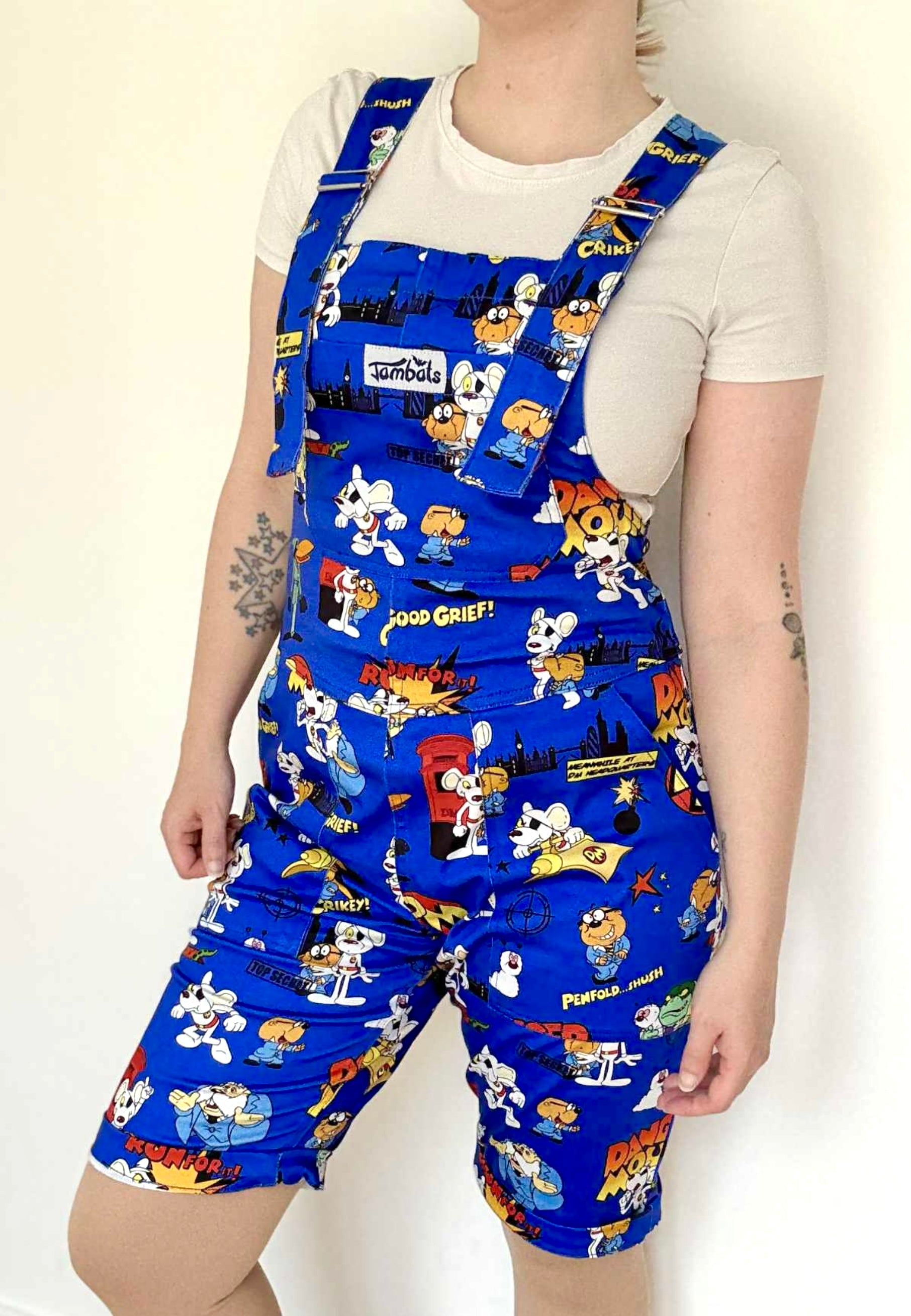 Woman wearing blue Jambats dungarees with the retro 80s cartoon characters DangerMouse on the print. Officially licensed