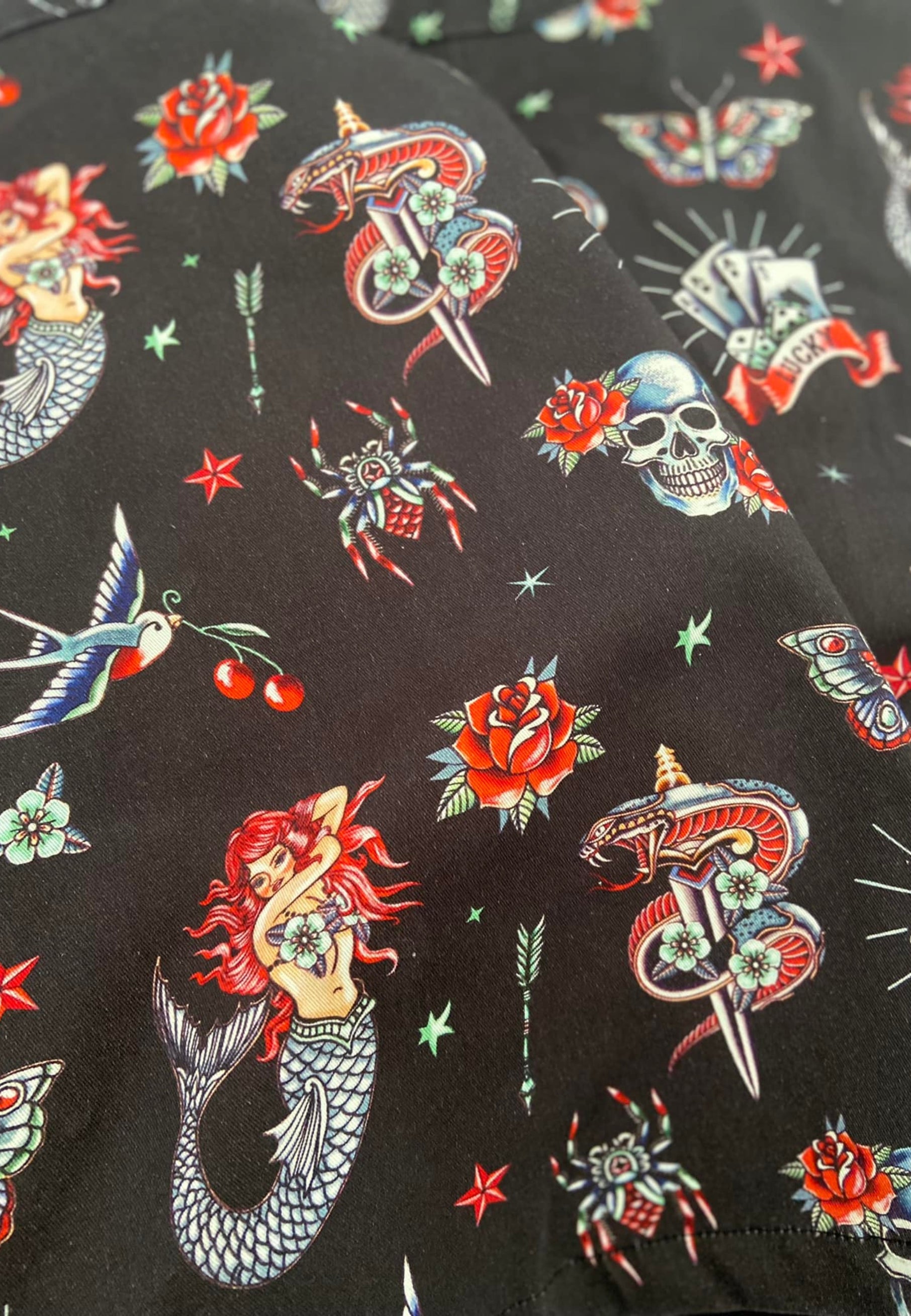 Close up of Jambats Old School Ink Tattoo fabric showing retro tattoos on a black background