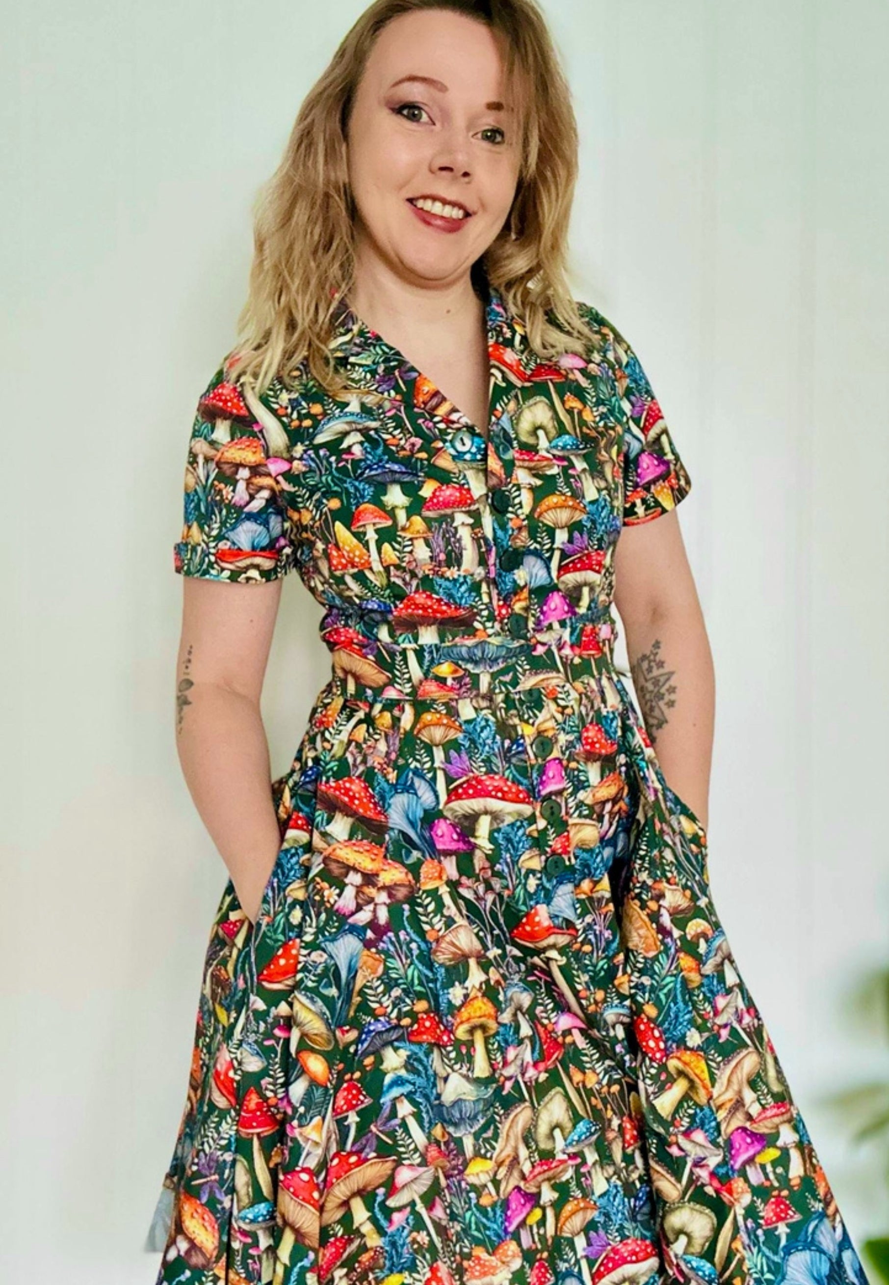 Woman wearing a beautiful  mushroom print dress against a plain background. 