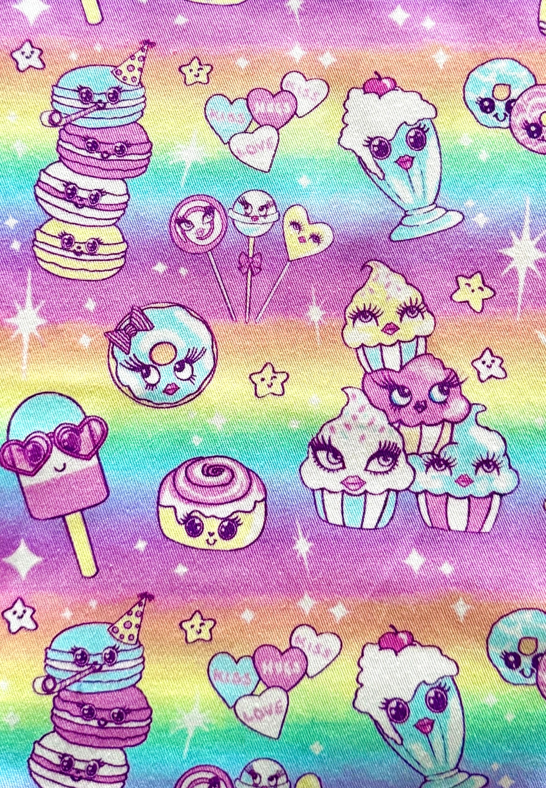 Colorful dessert-themed fabric with macarons, ice cream, and donuts on a rainbow background.
