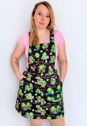 A woman wearing a black pinafore dress with a colourful pattern of hippie peas at a peas and love festival