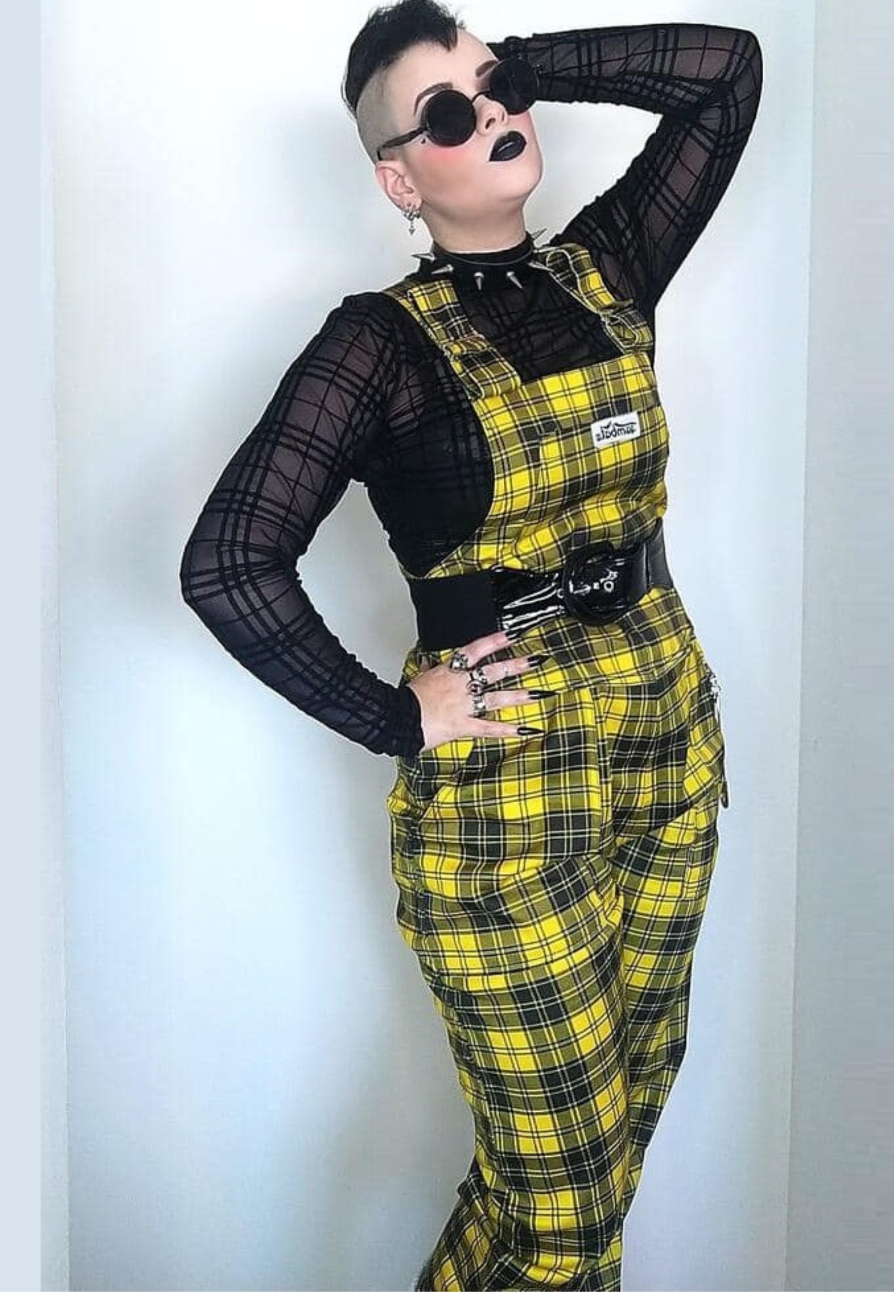 Woman in yellow and black dungarees. Looking alternative and punky. 