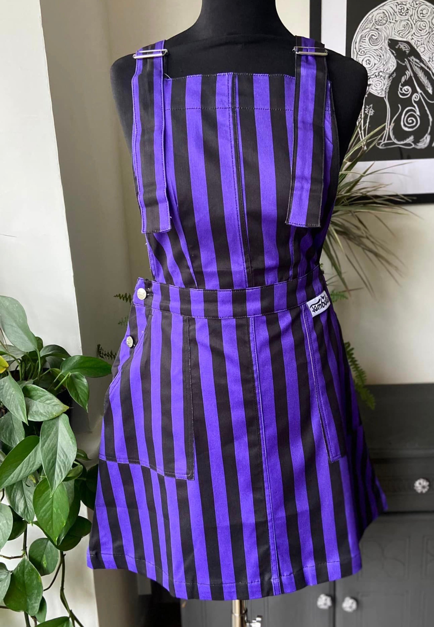 Purple and black striped pinafore dress on a mannequin. Jambats. 
