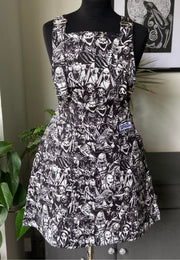 A pinafore dress featuring a black and white horror-themed print, displayed on a mannequin.