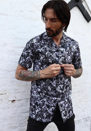 Man wearing a shirt with a gothic print in a grayscale of all the old school monster, cryptoids and zombies all screaming. In the style of the old horror comics. Horror goth style unisex shirt.