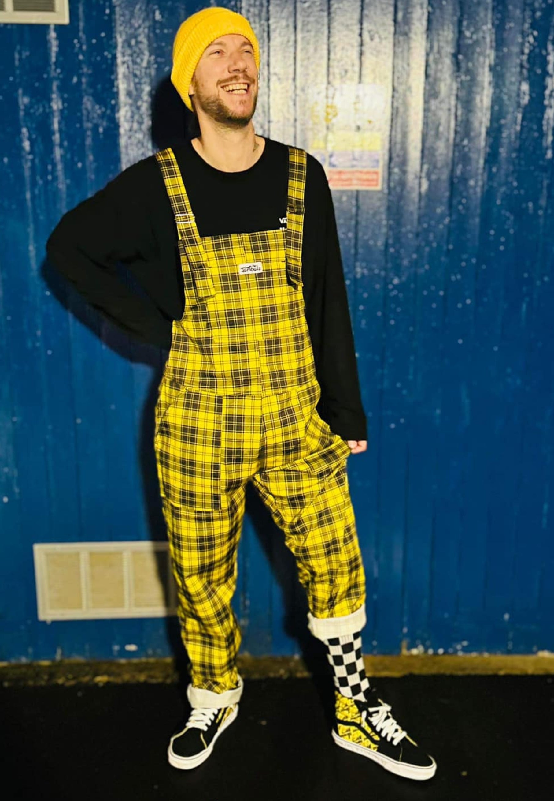 Man wearing fun yellow and black tartan dungarees.  