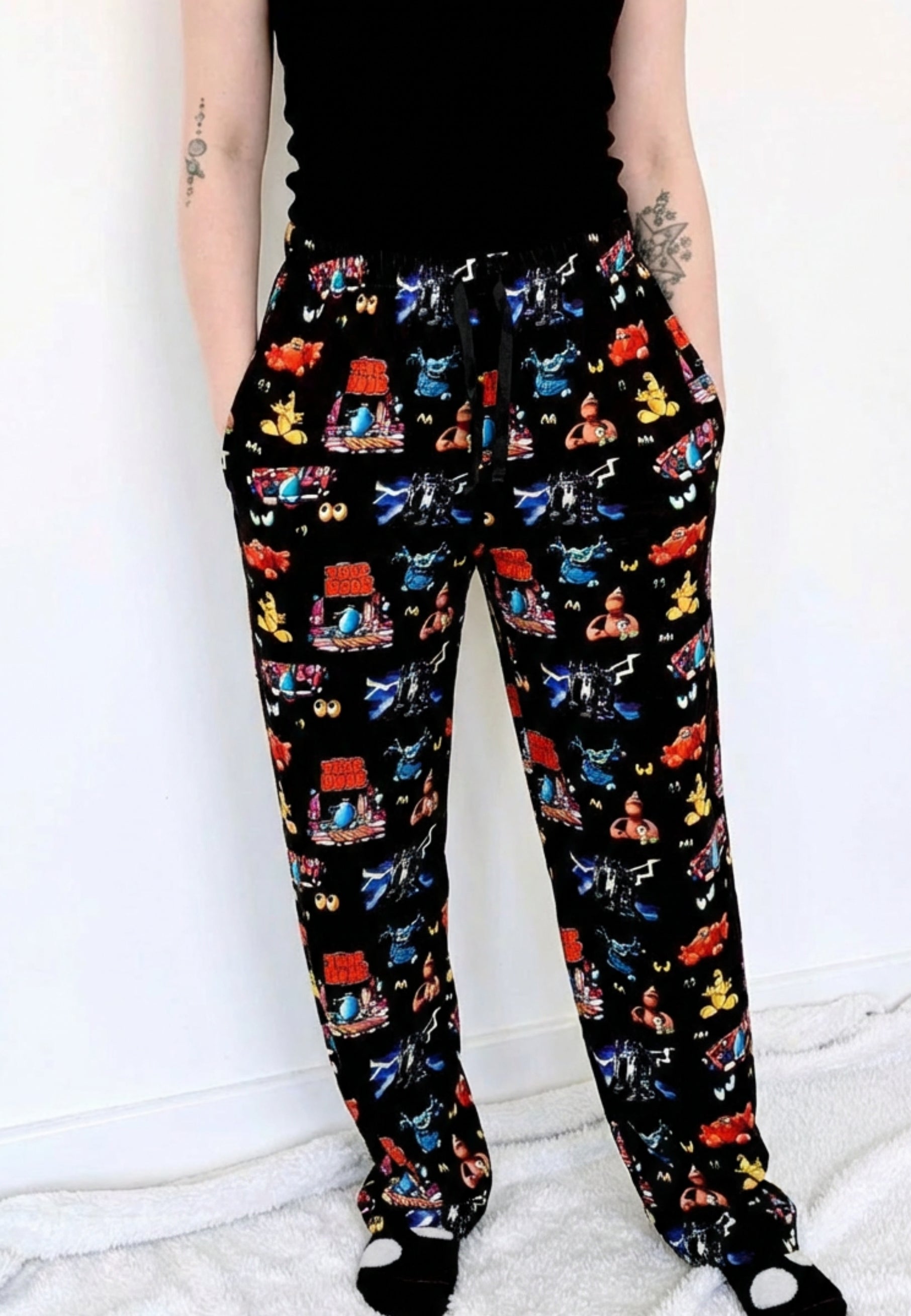 Lounge pants with a vibrant and retro Trap Door design on a black background