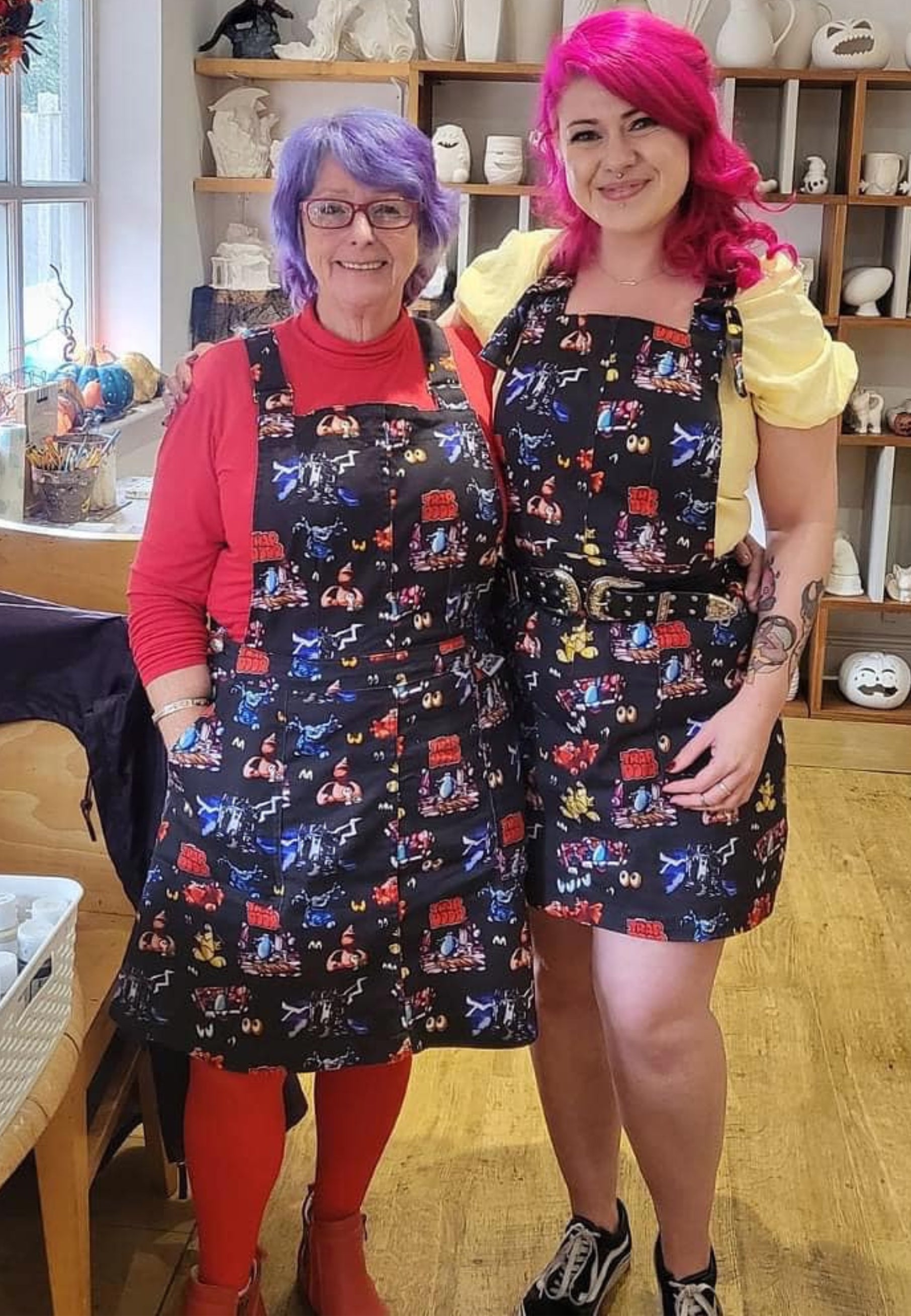 Two people wearing Trap Door pinafores. Jambats pinafores.