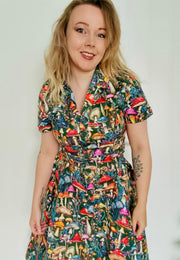 Woman wearing a beautiful  mushroom print dress against a plain background