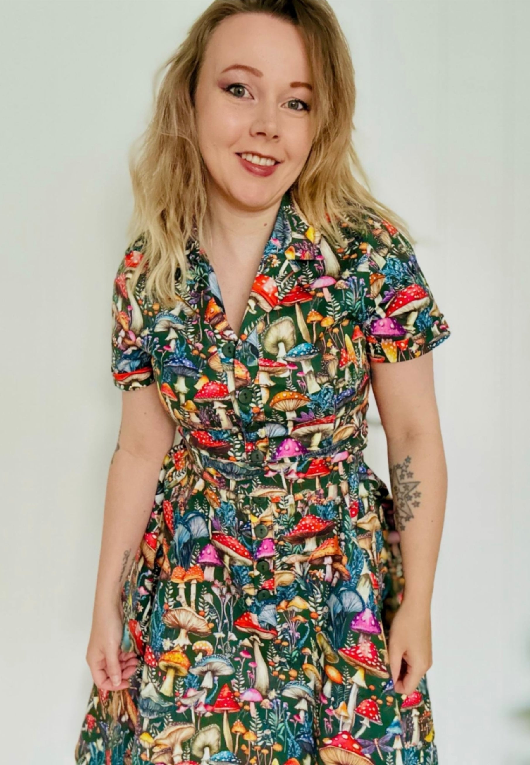 Woman wearing a beautiful  mushroom print dress against a plain background
