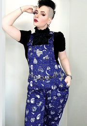 Woman wearing deep
Blue zodiac celestial print dungarees. 
