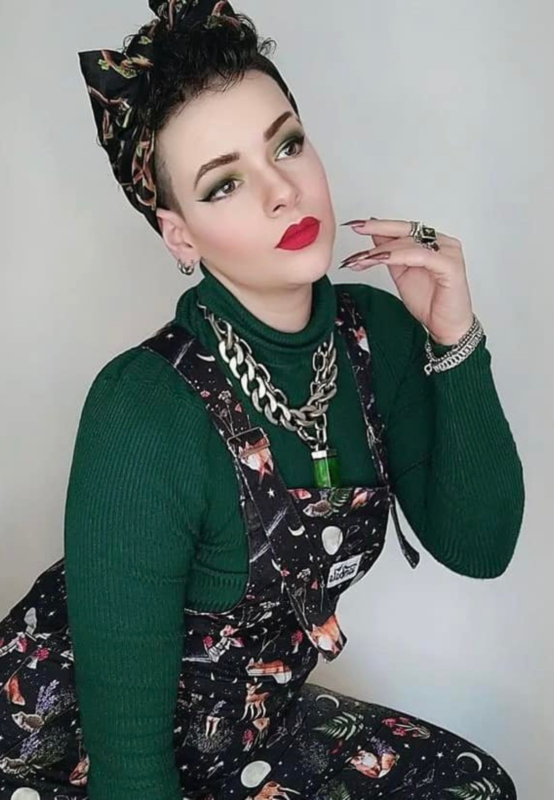 A model wearing Jambats Dark Forest dungarees. Black print with  moonlit forest, stars, shooting stars, moons and night dwelling creatures like owls, foxes, deer. Beautiful overalls. 