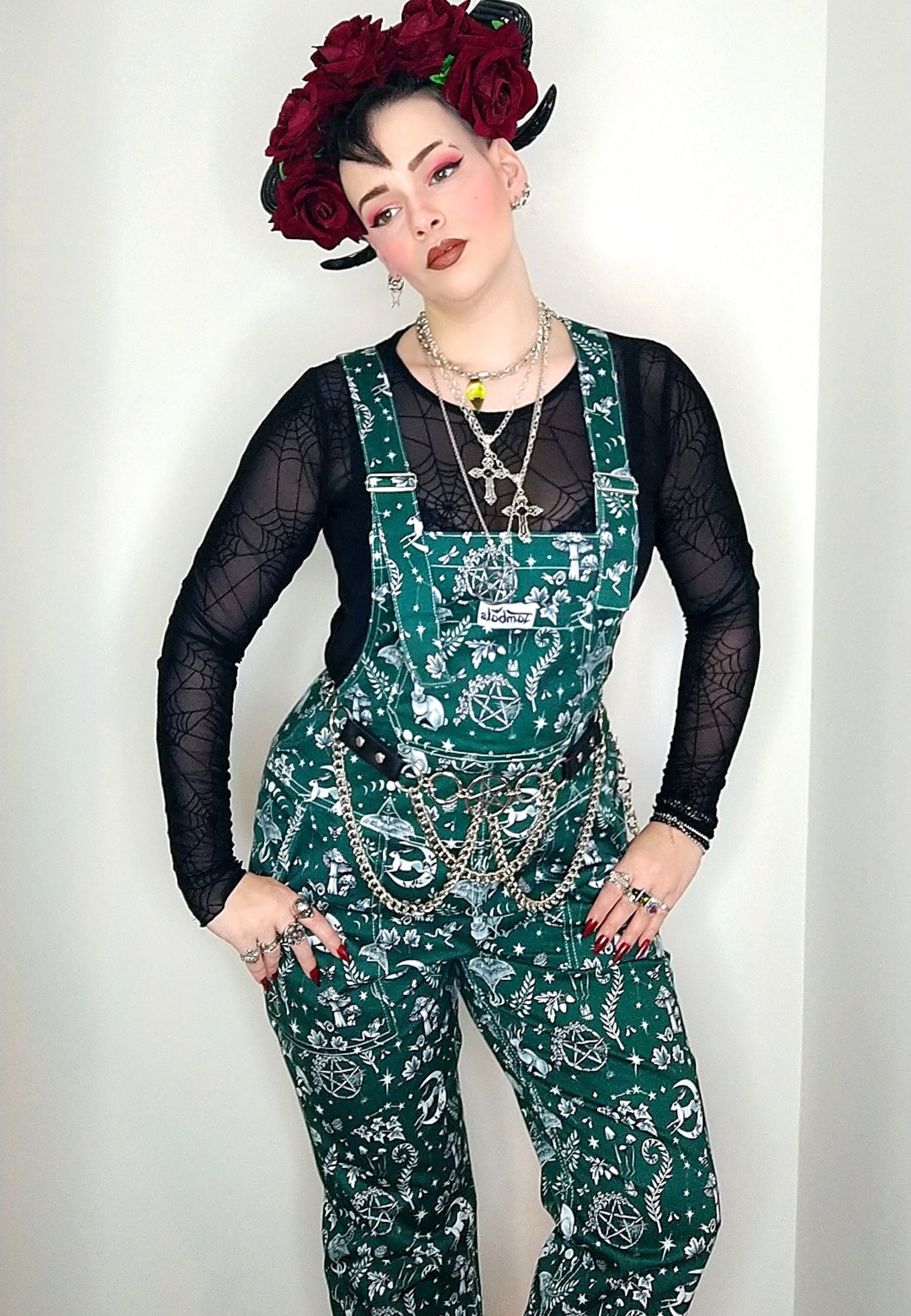 A woman wearing Jambats Spirit of Magick print. Deep green background with a white Magick print, including moon and hare, luna moth, and other magical elements. Woman is wearing a gothic floral head-dress, alternative flower crown 
