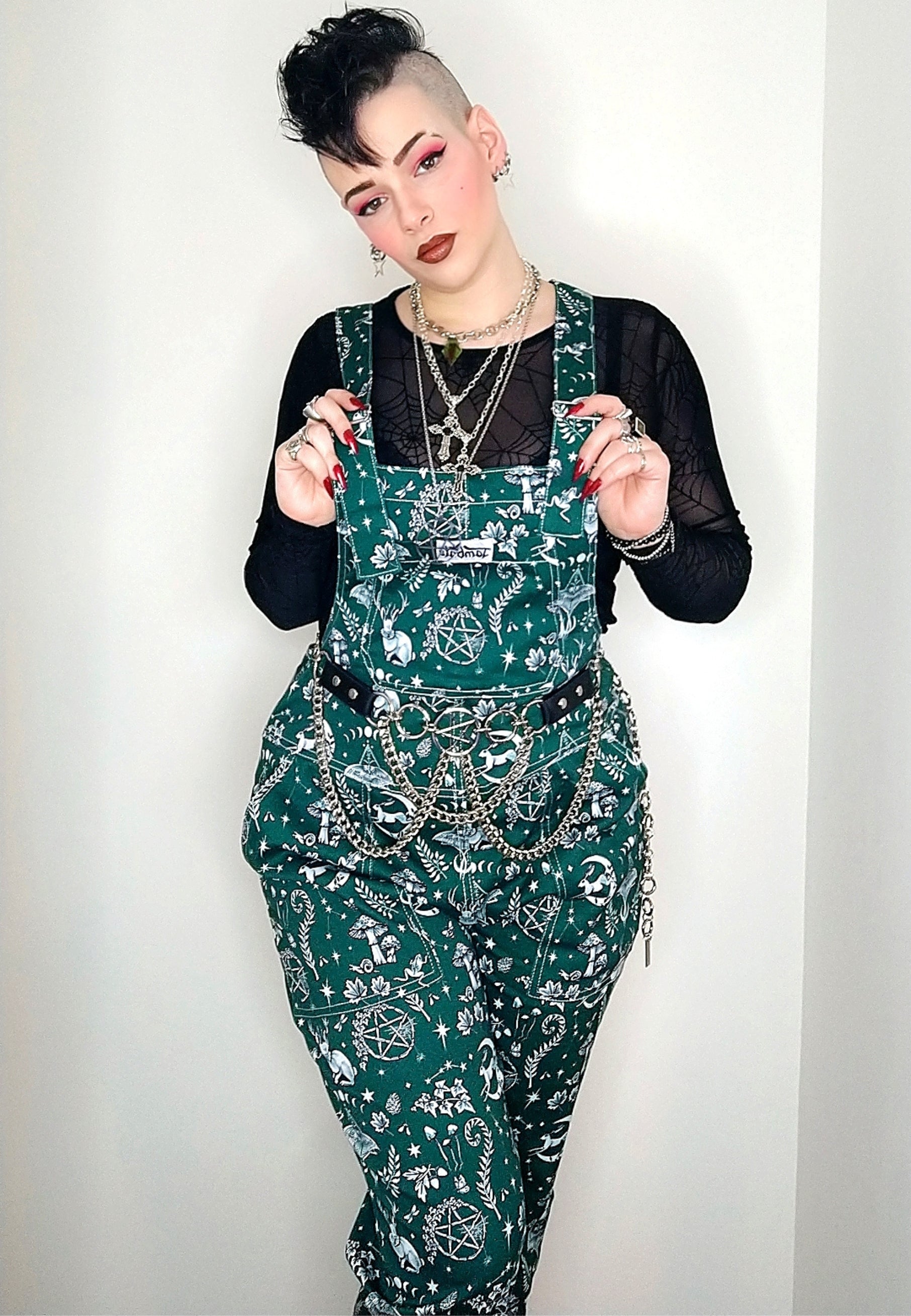 A woman wearing Jambats Spirit of Magick print. Deep green background with a white Magick print, including moon and hare, luna moth, and other magical elements. Alternative styling.