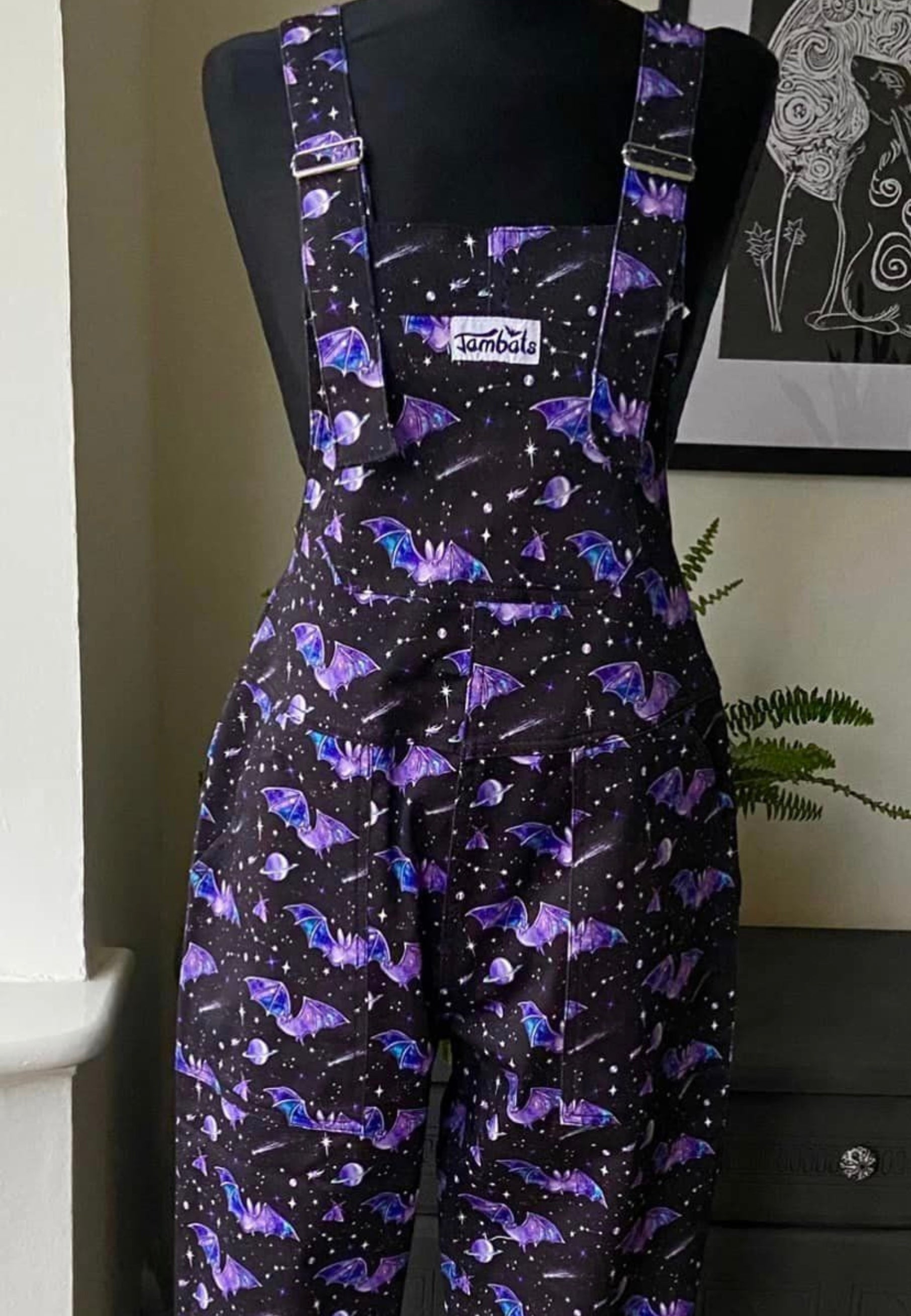 Beautiful Black dungarees with a purple cosmic bats print. Dungarees on a mannequin 